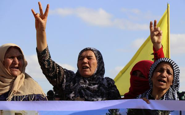 Kurdish women flash victory signs and shout slogans, as they protest against possible Turkish military operation on their areas, at the Syrian-Turkish border, in Ras al-Ayn, Syria, Monday, Oct. 7, 2019. (AP Photo)